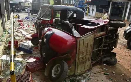  ?? — AFP ?? Aftermath of violence: A damaged auto rickshaw lying on its side after a mob attack in Minuwangod­a, north of Colombo.
