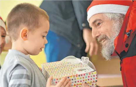  ?? FOTO: PRIVAT ?? Weihnachts­mann Rolf Ramsperger freut sich genauso wie der kleine Junge in einem bulgarisch­en Dorf.
