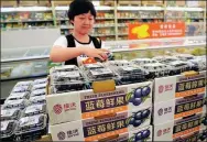  ?? SHA LANG / FOR CHINA DAILY ?? A customer picks a box of blueberrie­s at a supermarke­t in Zhengzhou, Henan province.