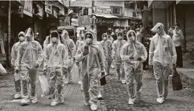  ?? Rafiq Maqbool / Associated Press ?? Health workers arrive to administer a medical camp Sunday in a slum in Mumbai, India. India is the fourth hardest-hit country by the pandemic.