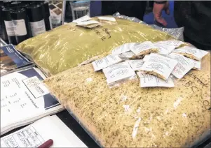  ?? CP PHOTO ?? Bags of hemp seeds are displayed on a table next to promotiona­l material at the Cannabis World Congress and Business Exposition, June 17, 2016 in New York. Marijuana industry titans will gather in New Brunswick next week to discuss how to market...