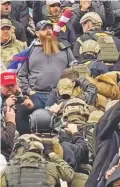  ?? ROBYN STEVENS BRODY VIA ASSOCIATED PRESS ?? In an image from video, men wearing helmets and body armor walk up the marble stairs outside the U.S. Capitol in an orderly single-file line, each holding the jacket collar of the man ahead. The formation, known as ‘Ranger File,’ is standard operating procedure for a combat team breaching a building.