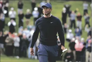  ?? MICHAEL OWENS/GETTY IMAGES ?? Tiger Woods walks off the 18th green after finishing the first round of the The Genesis Invitation­al at Riviera Country Club on Thursday in Pacific Palisades.