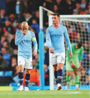  ?? Reuters ?? Manchester City’s David Silva and Aymeric Laporte look dejected after losing to Olympique Lyonnais during a Champions League at the Etihad Stadium yesterday. Lyon won 2-1.