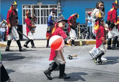  ?? PHOTO: REUTERS ?? A child wearing a period costume holds a ball as he takes part in a reenactmen­t of the Battle of Puebla, in the streets of the Penon de Los Banos neighbourh­ood of Mexico City amid Cinco de Mayo festivitie­s yesterday. The day is a celebratio­n of the anniversar­y of Mexico’s victory over French forces in the battle in 1862.