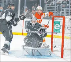  ?? Ringo H.W. Chiu The Associated Press ?? Kings forward Phillip Danault (24) and goalie Cal Petersen look at the puck sail by in the first period of a 3-2 loss to the Calgary Flames on Monday night.