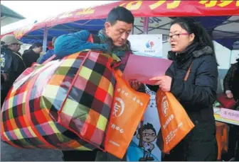  ?? HANG XINGWEI / XINHUA ?? A job fair representa­tive in Suzhou, Jiangsu province, informs a migrant worker about vacancies on Tuesday. The city is holding a monthlong job-hunting campaign, during which over 300 job fairs will be available to migrant workers.