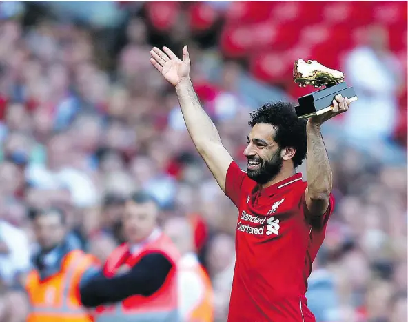  ?? — AP PHOTO ?? Liverpool’s Mohamed Salah lifts up his golden boot award after a 4-0 win over Brighton and Hove Albion at Anfield on Sunday. Salah earned the boot by leading the Premier League in goals with 32. Liverpool finished in fourth place for the second...