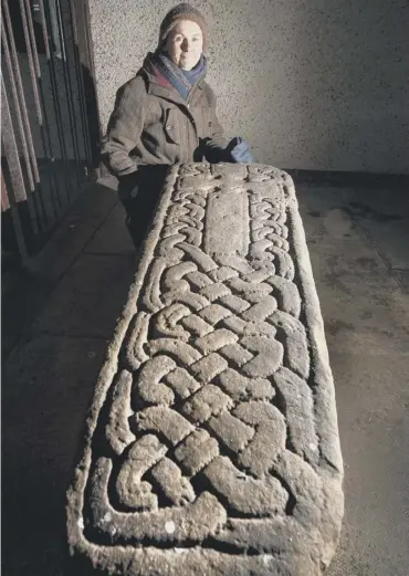  ??  ?? 0 Archeologi­st Dr Heather James next to one of the ancient burial stones in Inchinnan