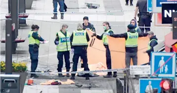  ??  ?? Emergency services and police work at the scene where a truck crashed into the Ahlens department store at Drottningg­atan in central Stockholm, April 7, 2017. AFP PHOTO