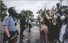  ?? TSONG-TAATARII/STAR TRIBUNE VIA AP RICHARD ?? Protesters and police face each other during a rally for George Floyd in Minneapoli­s in 2020.
