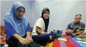  ?? (Foto Siti Rohana Idris/bh) ?? Mazlina bersama suami, Mohd Riduan Harun, serta anak mereka, Nur Aliya Maisara Mohd Riduan yang berpindah di PPS SMK Beris Panchor, Bachok, semalam.