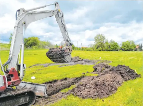  ?? FOTO: PAUL MARTIN ?? Ein Bagger schaufelt Löcher in die Wiese am Löhleweg in Kißlegg. Ein Gutachten soll klären, ob sich der Boden für eine Erschließu­ng eignet.