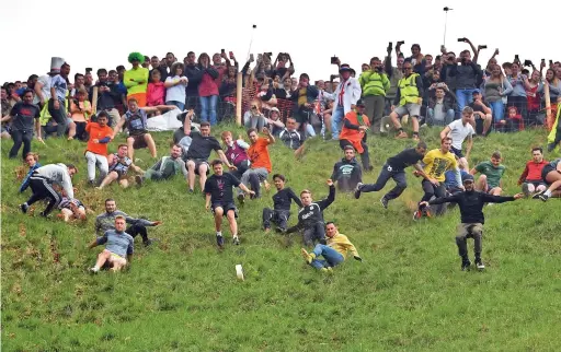  ?? Picture: Ben Birchall/pa Wire ?? Participan­ts take part in the annual cheese rolling competitio­n at Cooper’s Hill in 2019