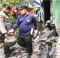  ?? AHMAD KHUSAINI/JAWA POS ?? GOSONG: Petugas Labfor Mabes Polri membawa LPG 3 kilogram dan kompor yang hangus untuk memastikan sumber api.