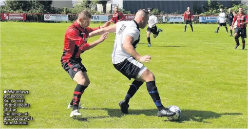  ??  ?? ● Waunfawr goalscorer Sion Jones (white) holds off the challenge of Bro Goronwy’s Tam Morton