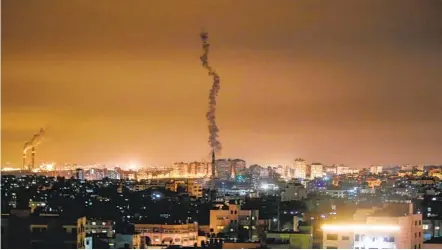  ?? MAHMUD HAMS GETTY IMAGES ?? The smoke trail of a rocket fired by Palestinia­n militants Sunday is seen lifting off from the Gaza Strip toward southern Israel. Israel responded with airstrikes against Islamic Jihad targets in Gaza and Syria. The militants fired at least 20 rockets.