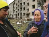  ?? EVGENIY MALOLETKA/AP ?? An evacuee, 79, says goodbye to her neighbors Tuesday after an airstrike in Lukiantsi, Ukraine.