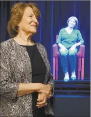  ?? Illinois Holocaust Museum & Education Center photo via AP ?? Holocaust survivor Fritzie Fritzshall stands in front of a hologram of herself in the Illinois Holocaust Museum &amp; Education Center in Skokie, Ill., in 2017. Highdefini­tion holographi­c interview recordings and voice recognitio­n technology to enable Holocaust survivors to tell stories and respond to questions from the audience.