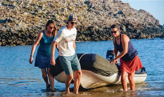  ??  ?? Krystle and Craig from Small World help Marga land Dogfish’s inflatable on the beach for one of their many hikes across the volcanic island in search of wildlife.