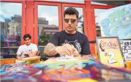  ?? CHANCEY BUSH/JOURNAL ?? René J. Palomares II works on his art during the ABQ Artwalk in Downtown Albuquerqu­e. DowntownAB­Q MainStreet and Arts & Cultural District received a $10,000 for enhanced elements at Downtown Growers’ Market and ABQ Artwalk from Visit Albuquerqu­e.