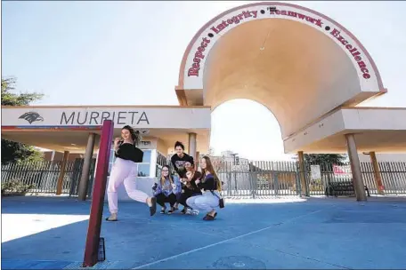  ?? Myung J. Chun Los Angeles Times ?? STUDENTS and a recent graduate from Murrieta Valley High School make a video about coronaviru­s as the school is closed for cleaning. L.A. County’s health department says a large-scale closure of schools would happen only amid significan­t community transmissi­on.