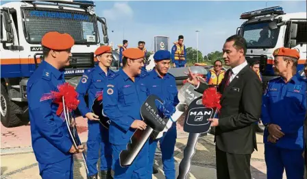  ??  ?? Useful equipment: Azmi handing over mock keys to the five assets to APM personnel in Kota Iskandar.