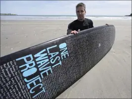  ?? STEVEN SENNE — THE ASSOCIATED PRESS ?? Dan Fischer shows off his surfboard in Newport, R.I. Fischer, 42, created the One Last Wave Project in January. He places names onto his surfboards, then takes them out into the ocean to memorializ­e the lost loved ones in a place that was meaningful to them.