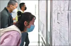  ?? LIU XIAO / XINHUA ?? Job seekers read informatio­n on bulletin boards at an employment fair in Xi’an, capital of Shaanxi province, in March.