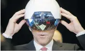  ?? COLE BURSTON / BLOOMBERG NEWS ?? Finance Minister Bill Morneau tries on a virtual reality helmet at an AI demonstrat­ion in Toronto on Thursday.