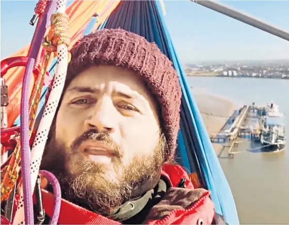  ?? ?? One of the Just Stop Oil protesters who scaled the Queen Elizabeth II bridge takes a selfie of the stunt. The protest forced police to close the crossing, causing hours of misery for motorists in Kent and Essex