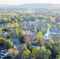  ?? TRIBUNE CONTENT AGENCY ?? The historic First Church of Christ in Farmington is visible in this aerial photo of the center of town.