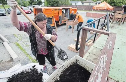  ?? MATHEW MCCARTHY WATERLOO REGION RECORD ?? Rebekah Haynes transfers soil as volunteers from Home Depot build raised beds for the gardening program at the Opportunit­y Centre.