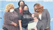  ?? TIMOTHY D. EASLEY/AP ?? Kentucky Gov. Andy Beshear signs a partial ban on no-knock warrants as Tamika Palmer, the mother of Breonna Taylor, back row center, and others watch.