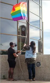  ?? Herald photo by Greg Bobinec ?? Javice Campbell and Marshall Vielle raise the Pride flag at Lethbridge City Hall, Monday evening, to celebrate and commemorat­e the annual Lethbridge Pride Fest. @GBobinecHe­rald