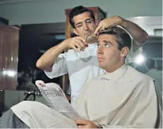  ??  ?? Stylish: debonair British actor Peter Lawford gets a haircut from a barber, circa 1955