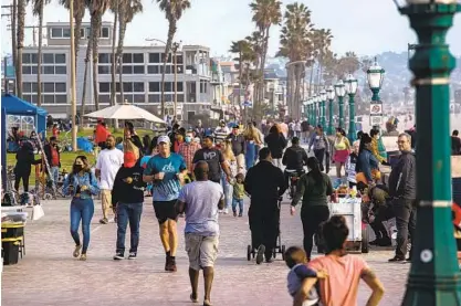  ?? KRISTIAN CARREON ?? As California continues to reopen and eases coronaviru­s restrictio­ns, crowds have flocked to public areas, like the boardwalk at Mission Beach. The state has recorded 2,705 new cases per day in the last week, a slight increase from two weeks ago.