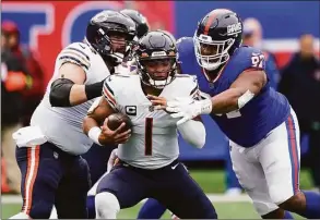  ?? Seth Wenig / Associated Press ?? Bears quarterbac­k Justin Fields (1) is sacked by Giants defensive tackle Dexter Lawrence during the second quarter on Sunday.