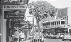  ?? AP PHOTOS ?? The old banyan tree rises 18 meters and covers nearly an acre in Lahaina, Hawaii. The tree’s multiple trunks and large canopy make it a great gathering place for events in town. Front Street is Lahaina’s main downtown street, home to bars, clubs,...