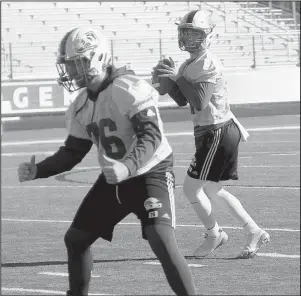  ?? The Sentinel-Record/James Leigh ?? OPTIONS: Arkadelphi­a junior quarterbac­k Cannon Turner (21) looks for passing options Thursday morning behind offensive lineman Matthew Parnham (76) during practice at AllCare Field as the Badgers prepared for today’s third-round playoff game at Stuttgart.