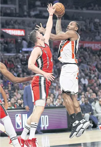  ??  ?? The Clippers’ Kawhi Leonard, right, shoots against Portland’s Mario Hezonja at Staples Center.