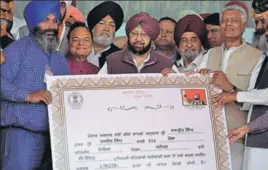  ??  ?? ■ CM Capt Amarinder Singh (C) and other Congress leaders presenting a debt waiver certificat­e to a farmer, Harpreet Singh, at a function in Nakodar on Wednesday. PARDEEP PANDIT/HT