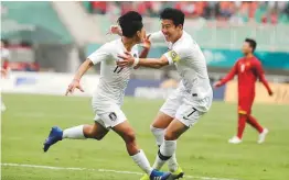  ?? AP ?? South Korea’s Lee Seung-woo (left) celebrates his goal with teammate Son Heung-min after scoring against Vietnam in the semi-final.