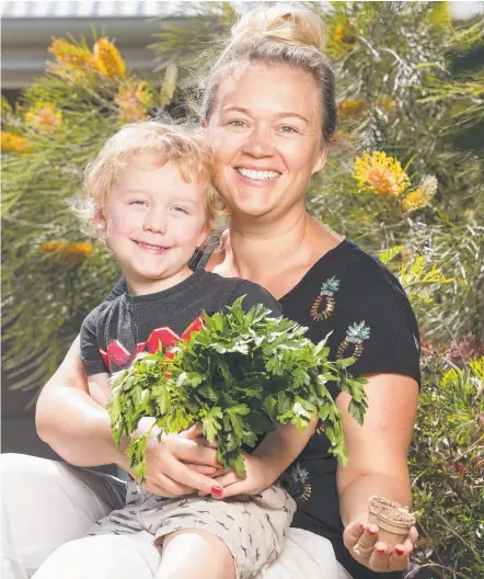  ?? Picture: LACHIE MILLARD ?? Stephanie Walker and her son Harry with some of their homegrown parsley and seedlings.
