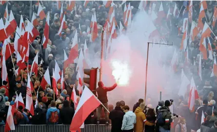  ?? | Reuters ?? PEOPLE carry Polish flags and flares during a march marking the 100th anniversar­y of Polish independen­ce in Warsaw, Poland, yesterday.