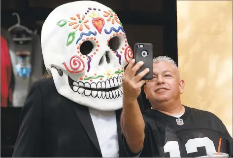  ?? KARL MONDON — STAFF ARCHIVES ?? Arnold Gonzalez takes a selfie with George Romero, who is hiding under a huge painted skull mask, at last year’s Day of the Dead event at Mexican Heritage Plaza in San Jose.