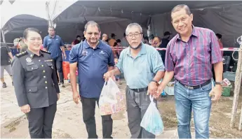  ?? ?? Mohamad (second right) poses with Rohaizi (second le ) a er purchasing some items at the programme. Flanking them are KPDNHEP Kapit officer Megawathy Salleh and KPDNHEP corporate communicat­ion head Yunus Tasim.