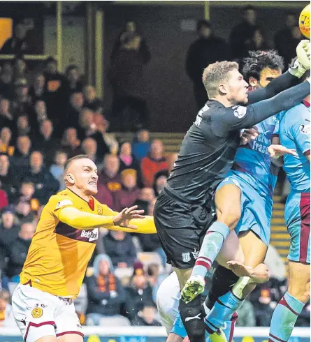  ?? Pictures: SNS. ?? Above: Dundee’s Jack Hamilton rises high to punch clear a cross from the Dundee box. Left: Motherwell’s Curtis Main holds of Dundee’s Lewis Spence and Andy Boyle.