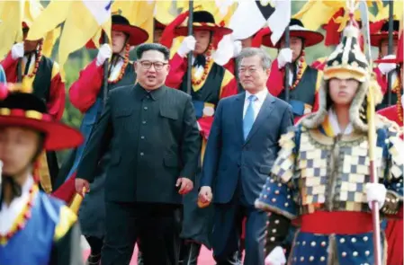  ?? AP PRESS POOL ?? North Korean leader Kim Jong Un and South Korean President Moon Jae-in walk together through an honor guard at the border village of Panmunjom in the Demilitari­zed Zone in Korea. It was the first time a North Korean leader had been in the South.