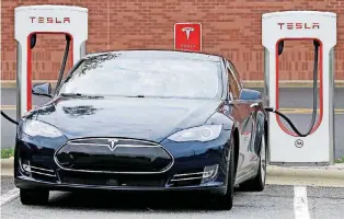  ?? [AP PHOTO] ?? A Tesla car recharges at Cochran Commons shopping center in Charlotte, N.C. Tesla’s shares are shaping up to possibly have their worst week of the year so far as lowerthan-expected production, increased competitio­n and a review from an industry group...